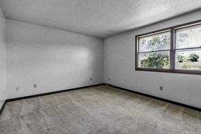 Amherst triplex for rent - A room with a window and carpeted floor.