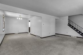 Amherst triplex for rent - A spacious room with a staircase and a window.