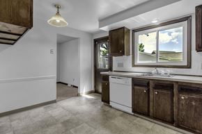 Amherst triplex for rent - A kitchen with a white dishwasher and dark brown cabinets.