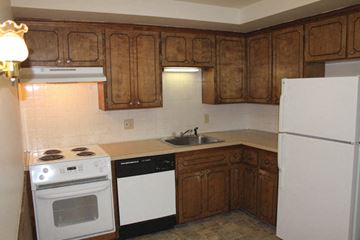 Tonawanda apartment for rent - A kitchen with wooden cabinets and a white refrigerator.