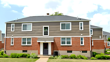 Buffalo apartment for rent - A two-story house with a grey roof and a brick facade.