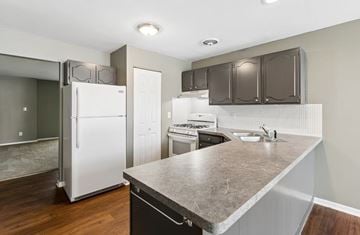 Amherst apartment for rent - A kitchen with a white fridge and brown cabinets.