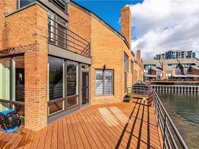 Buffalo house for rent - A building with a wooden deck overlooking a body of water.