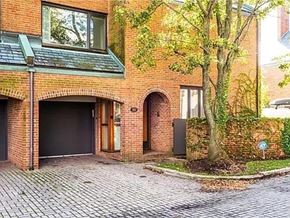 Buffalo house for rent - A red brick house with a black garage door.