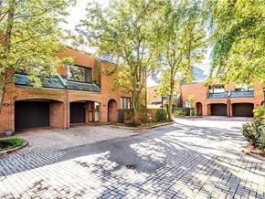 Buffalo house for rent - A large brick house with a driveway and trees.