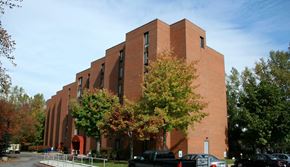Buffalo apartment for rent - A large red brick building with trees in front.