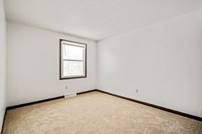 Amherst triplex for rent - A room with a carpeted floor and a window.