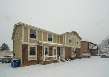 Amherst triplex for rent - A house with a brown and beige exterior is surrounded by snow.