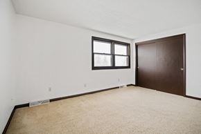 Amherst triplex for rent - A room with a brown door and a window with a white frame.
