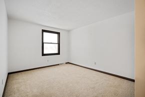 Amherst triplex for rent - A room with a carpeted floor and a window.