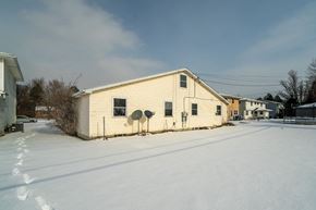 Amherst triplex for rent - A house with a satellite dish on the roof is surrounded by snow.