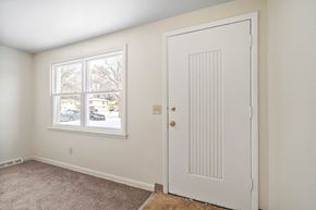 Amherst triplex for rent - A room with a white door and a window showing a street view.