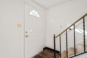 Amherst triplex for rent - A white door with a gold handle and a window above it.