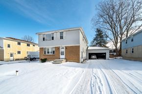 Amherst triplex for rent - A house with a driveway covered in snow.