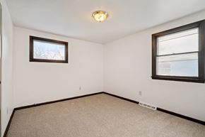 Amherst triplex for rent - A room with a carpeted floor and two windows.