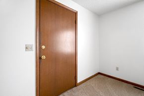 Amherst apartment for rent - A brown door with a brass handle is in a room with white walls.