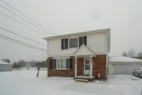 Amherst triplex for rent - A house with a snowy front yard.