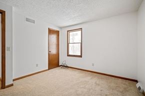 Amherst triplex for rent - A room with a door, a window, and a carpet.