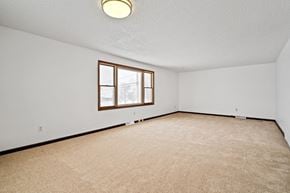 Amherst triplex for rent - A room with a carpeted floor and a window.