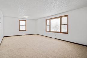 Amherst triplex for rent - A room with a carpeted floor and two windows.