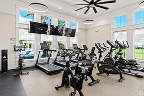 Miami apartment for rent - A spacious gym with treadmills, elliptical machines, and a television.