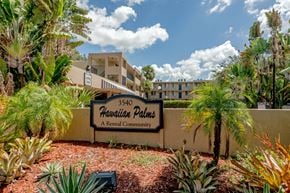 Lauderdale Lakes apartment for rent - A sign for Hawaiian Palms A Rental Community is in front of a building.