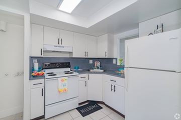 Lauderdale Lakes apartment for rent - A kitchen with white appliances and a black mat on the floor.