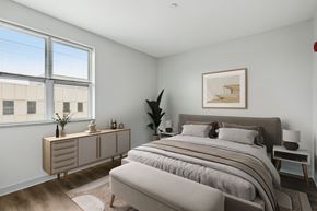 Pittsburgh apartment for rent - A bedroom with a large bed and a window overlooking a building.