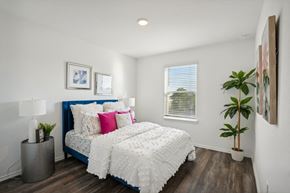Katy apartment for rent - a bedroom with a bed and a plant