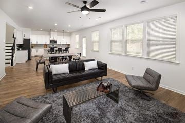 Grayson apartment for rent - A modern living room with a black couch and a grey armchair.