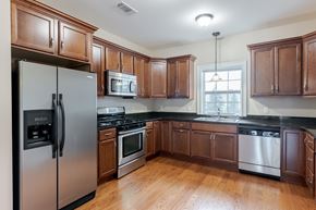 Highland apartment for rent - A kitchen with wooden cabinets and stainless steel appliances.