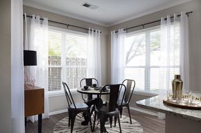 Kansas City apartment for rent - City Place at Westport - Furnished Dining Room With Circular Table, Chairs, and Windows With Blinds and Curtains