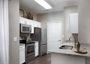 Kansas City apartment for rent - City Place at Westport - Modern Kitchen With Granite Countertops, Stainless Steel Appliances, and Wood Floors