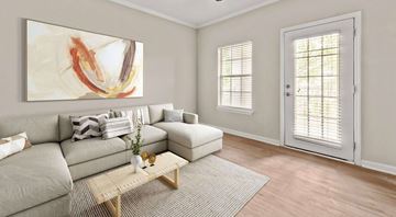 Fairburn apartment for rent - A living room with a grey couch, a wooden coffee table, and a painting on the wall.