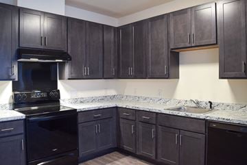 Flemington apartment for rent - a kitchen with black cabinets and granite counter tops and black appliances