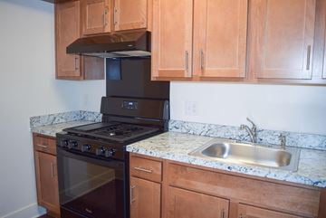 Elkton apartment for rent - a kitchen with wooden cabinets and black appliances and a sink