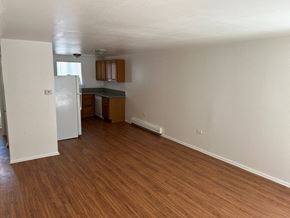 Denver apartment for rent - A kitchen with white walls and wooden floors.