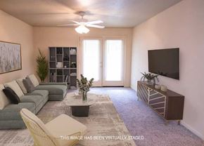 Tuscaloosa apartment for rent - Spacious living area with a ceiling fan and plush carpeting