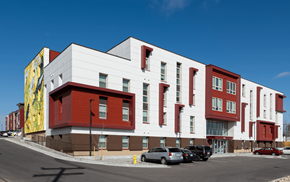 Denver apartment for rent - a large red and white building with cars parked in front of it