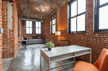 St. Louis apartment for rent - a living room with brick walls and a table and chairs
