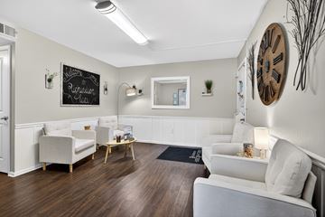 Arnold apartment for rent - A living room with white furniture and a large clock on the wall.
