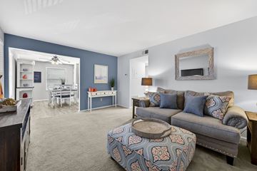 Arnold apartment for rent - A living room with a grey couch and a patterned ottoman.