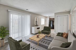 Cincinnati apartment for rent - A living room with a green couch, a wooden coffee table, and a potted plant.