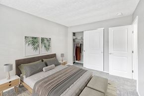 Cincinnati apartment for rent - A bedroom with a bed, nightstand, and two framed pictures on the wall.