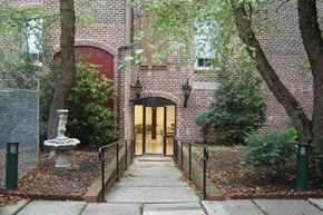 Petersburg apartment for rent - the entrance to a brick building with trees and a sidewalk