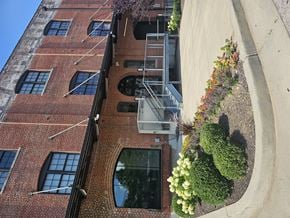 Memphis apartment for rent - A red brick building with a flower bed in front of it.
