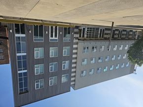 Memphis apartment for rent - A tall building with a lot of windows is shown from a low angle.