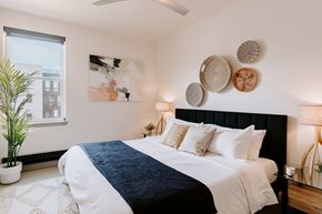 Denver apartment for rent - A bedroom with a large bed and a plant.