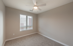 Denver apartment for rent - an empty bedroom with a ceiling fan and a window