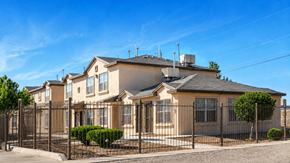 Anthony townhouse for rent - A row of houses with a black fence in front.
